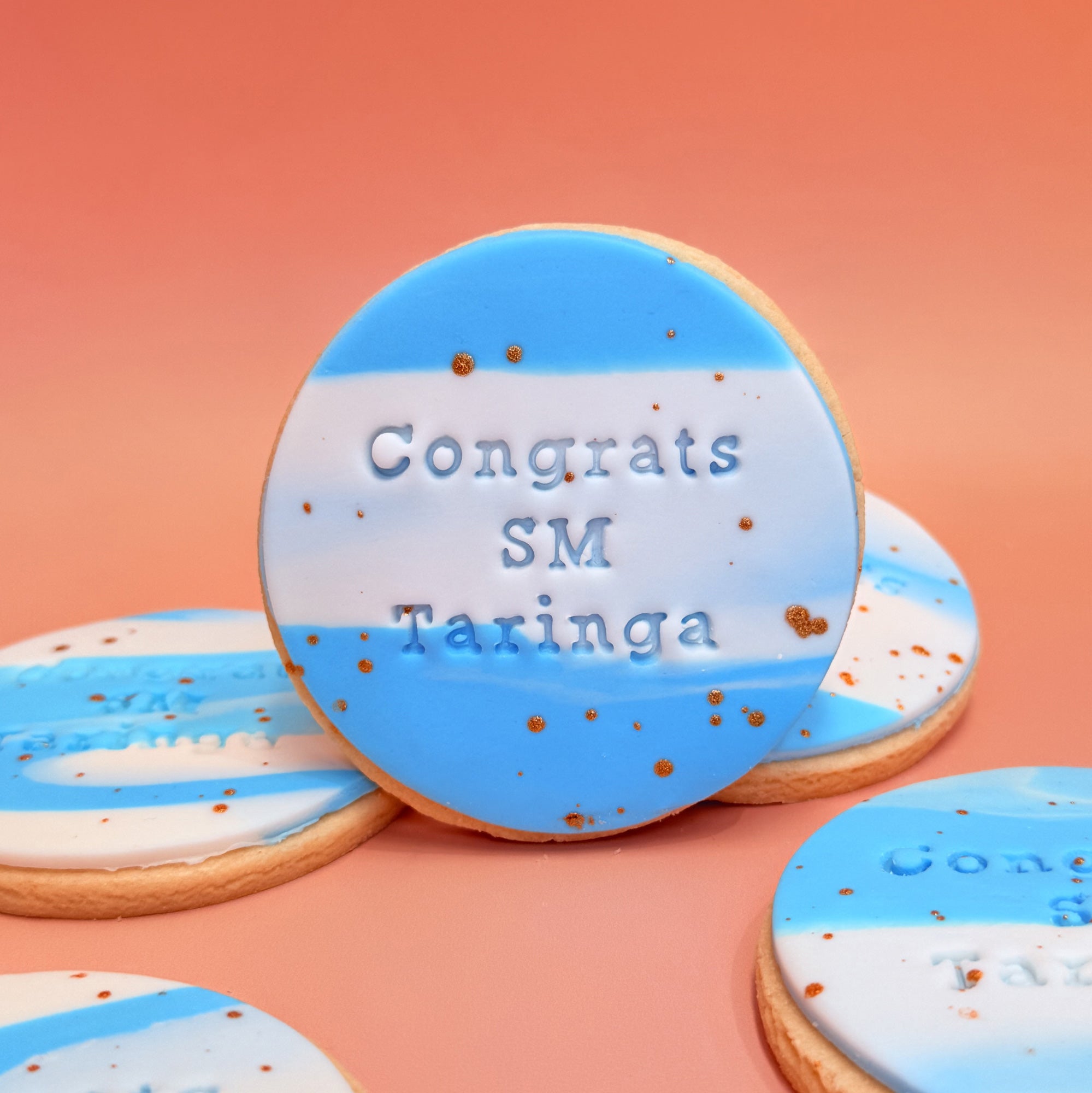 Decorated cookies with blue and white icing and text on a peach background. Sugar Rush by Steph